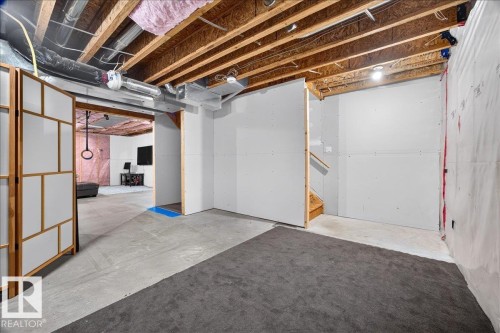 Unfinished basement space featuring exposed wood joists, ductwork, and partial drywall installation - 3043 Keswick Way Sw, Edmonton, AB - Indoor Photo Showing Basement