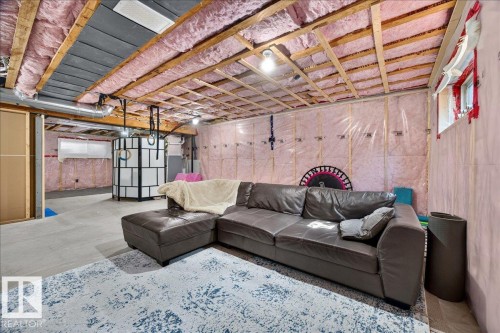 Unfinished basement area featuring exposed ceiling joists and insulation, concrete flooring, and partial framing - 3043 Keswick Way Sw, Edmonton, AB - Indoor Photo Showing Basement