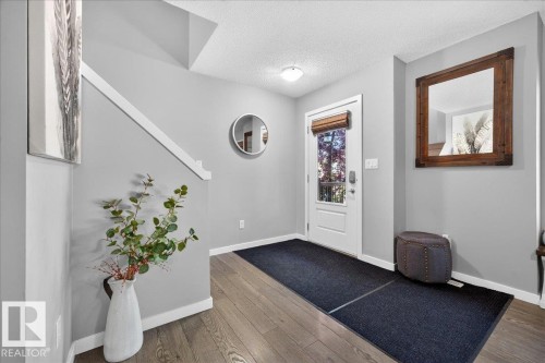 Entryway featuring wood-finish flooring, light gray walls, white trim, and a white paneled door with window and blind - 3043 Keswick Way Sw, Edmonton, AB - Indoor Photo Showing Other Room