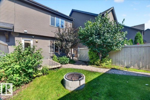 Private backyard featuring a manicured lawn, established trees, and a paver stone pathway - 3043 Keswick Way Sw, Edmonton, AB - Outdoor