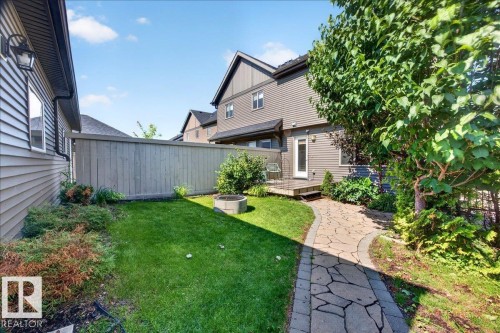 Manicured lawn with a flagstone pathway, a privacy fence, and mature landscaping - 3043 Keswick Way Sw, Edmonton, AB - Outdoor