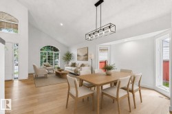 Open-concept living area featuring vaulted ceilings, wood-finish flooring, and multiple arched windows - 