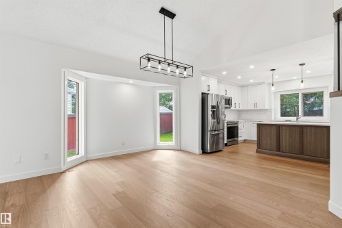 Open-concept kitchen and dining area featuring light wood-finish flooring - 140 Healy Road Nw, Edmonton, AB - Indoor Photo Showing Kitchen
