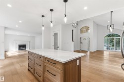 Central kitchen island with a stone-finish countertop and wood-finish cabinetry - 