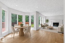 Open-concept living space featuring wood-finish flooring, recessed lighting, and a white marble-surround fireplace - 
