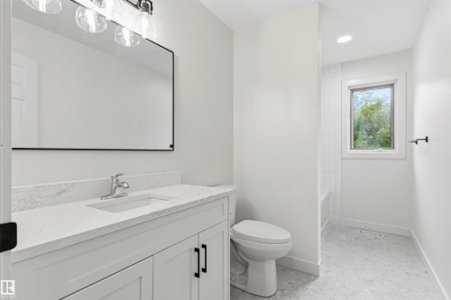 Bathroom featuring a white vanity with a quartz countertop, an undermount sink, and matte black hardware - 140 Healy Road Nw, Edmonton, AB - Indoor Photo Showing Bathroom
