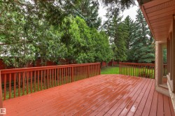 Spacious outdoor deck with reddish-brown wood planks and matching railing - 