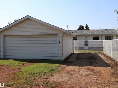 Detached garage with horizontal siding, a pitched roof, and a panel garage door - 4306 - 55 Ave, Barrhead, AB - Outdoor With Exterior
