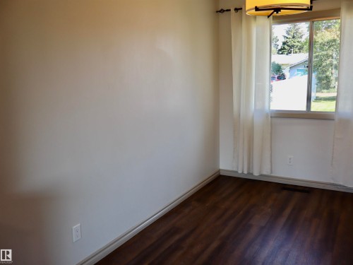 Windowed interior space featuring dark wood-finish flooring - 4306 - 55 Ave, Barrhead, AB - Indoor Photo Showing Other Room