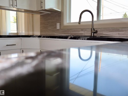 Polished dark countertop reflecting natural light - 4306 - 55 Ave, Barrhead, AB - Indoor Photo Showing Kitchen