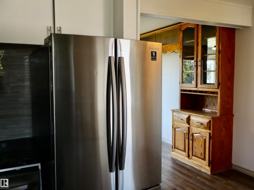 Stainless steel refrigerator paired with light cabinetry and dark countertops - 4306 - 55 Ave, Barrhead, AB - Indoor