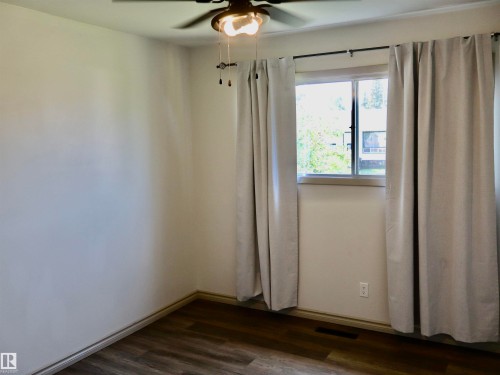 Room with neutral wall paint, wood-finish flooring, and a ceiling fan with integrated lighting - 4306 - 55 Ave, Barrhead, AB - Indoor Photo Showing Other Room