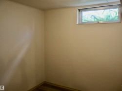 Interior space featuring a horizontal window, wood-finish flooring, and light-toned wall paneling - 