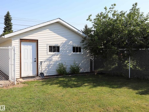 Detached auxiliary structure featuring white siding, a white entry door with dark trim, and two square windows - 4306 - 55 Ave, Barrhead, AB - Outdoor