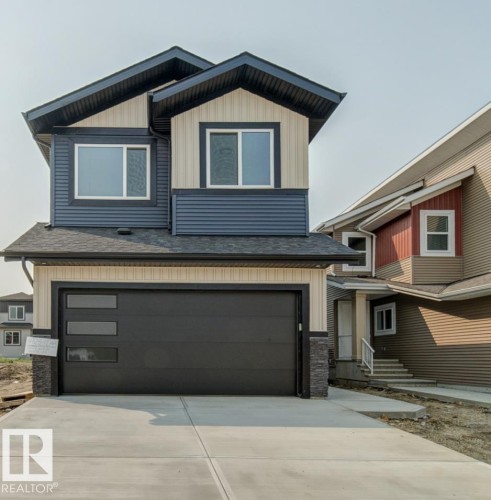Contemporary two-story exterior featuring a prominent black garage door with rectangular windows - 4723 17 Avenue Sw, Edmonton, AB - Outdoor