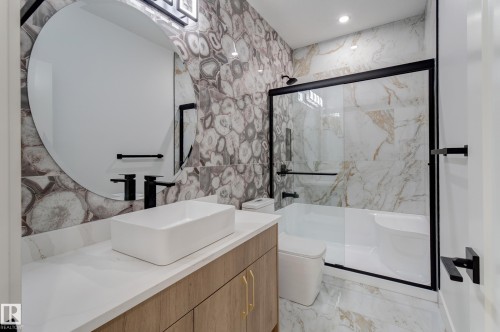 Contemporary bathroom featuring a vessel sink, a large circular mirror, and a wood-finish vanity - 4723 17 Avenue Sw, Edmonton, AB - Indoor Photo Showing Bathroom