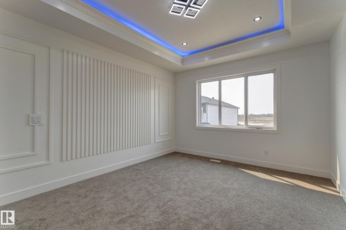 Recessed lighting and a multi-pane window illuminate this space featuring a decorative accent wall with vertical paneling and trim work - 4723 17 Avenue Sw, Edmonton, AB - Indoor Photo Showing Other Room