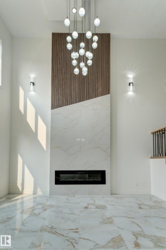 Modern fireplace wall with wood-slat detailing and large format stone-look tile - 4723 17 Avenue Sw, Edmonton, AB - Indoor Photo Showing Other Room With Fireplace