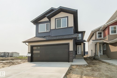 Contemporary two-story residence featuring a two-tone exterior with dark blue horizontal siding and light beige vertical siding - 4723 17 Avenue Sw, Edmonton, AB - Outdoor With Facade