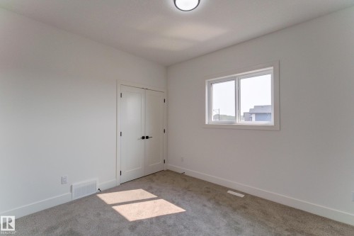 Neutral interior with light gray carpeting and white walls - 4723 17 Avenue Sw, Edmonton, AB - Indoor Photo Showing Other Room
