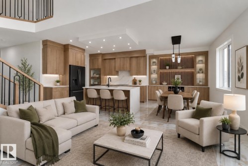 Open-concept living space featuring wood-finish cabinetry, a large kitchen island with seating, integrated dining area with built-in illuminated display shelving, and light-toned flooring - 4723 17 Avenue Sw, Edmonton, AB - Indoor Photo Showing Living Room