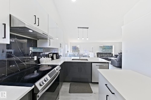 Contemporary kitchen with white upper and dark lower cabinetry and black hardware - 3799 21 Street Nw, Edmonton, AB - Indoor Photo Showing Kitchen