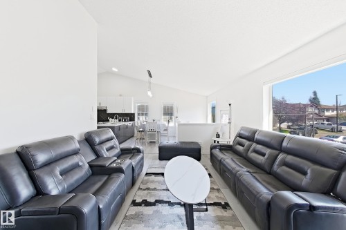 Open-concept living area featuring vaulted ceilings and light wood-finish flooring - 3799 21 Street Nw, Edmonton, AB - Indoor Photo Showing Living Room