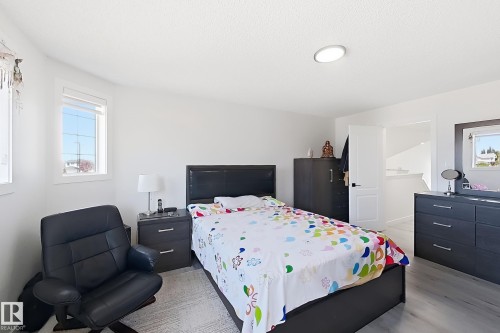 Bright bedroom featuring white walls, a recessed ceiling light, and two windows - 3799 21 Street Nw, Edmonton, AB - Indoor Photo Showing Bedroom