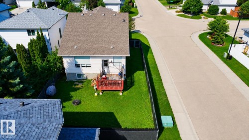 Rear exterior featuring a red-stained wood deck, white siding, and a shingle roof - 3799 21 Street Nw, Edmonton, AB - Outdoor