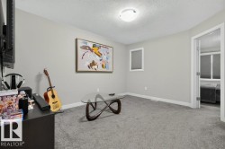 Carpeted room with light gray walls, a flush-mount ceiling light, and white baseboards - 