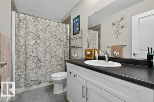 Bathroom featuring a white vanity with dark countertop, undermount sink, and chrome faucet - 848 Ebbers Crescent Nw, Edmonton, AB - Indoor Photo Showing Bathroom