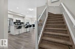 Staircase with carpeted treads and white wood railings - 