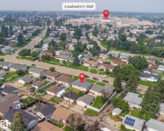Residential neighborhood featuring numerous single-story homes, mature trees, and paved streets - 