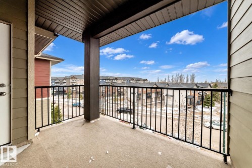 Covered outdoor balcony with concrete flooring and black metal railing - #404 12025 22 Av Sw, Edmonton, AB - Outdoor With Balcony With Exterior