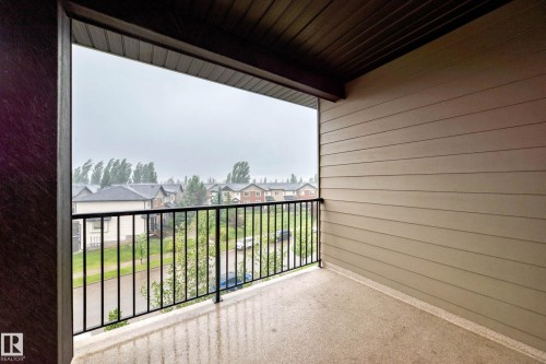 Private balcony featuring a textured concrete floor, durable exterior siding, and a black metal railing - #404 12025 22 Av Sw, Edmonton, AB - Outdoor With Balcony With Exterior