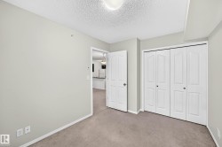 Neutral-toned wall paint with a textured ceiling, featuring a bi-fold closet door system - 