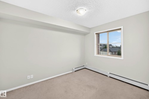 Light-colored carpeting complementing neutral wall tones - #404 12025 22 Av Sw, Edmonton, AB - Indoor Photo Showing Other Room