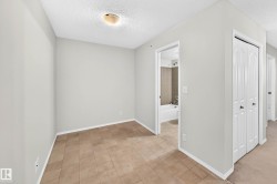 Room featuring light neutral walls, textured ceiling, flush mount ceiling light, and square tile flooring - 
