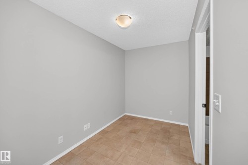 Room featuring light gray walls, textured ceiling, and a flush mount light fixture - #404 12025 22 Av Sw, Edmonton, AB - Indoor Photo Showing Other Room