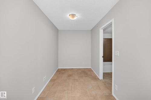 Interior room with neutral wall paint, tiled flooring, and a flush mount ceiling light fixture - #404 12025 22 Av Sw, Edmonton, AB - Indoor Photo Showing Other Room