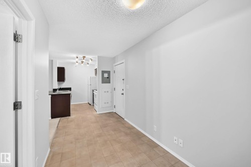 Tiled flooring extending into a bright living space - #404 12025 22 Av Sw, Edmonton, AB - Indoor Photo Showing Other Room