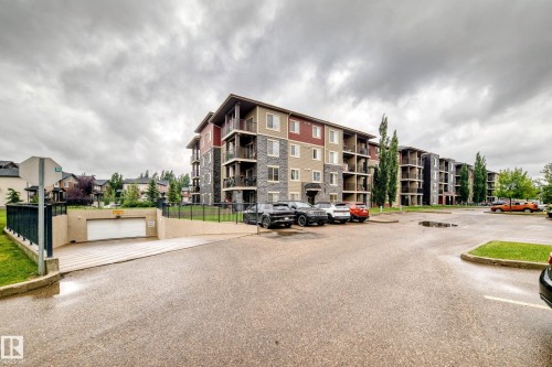 Residential building featuring multi-tone exterior siding with stone accents - #404 12025 22 Av Sw, Edmonton, AB - Outdoor With Balcony With Facade
