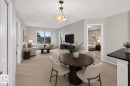 Open-concept living space with light-colored carpeting, a large window, and a built-in media console - #404 12025 22 Av Sw, Edmonton, AB  - Indoor Photo Showing Other Room 