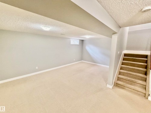 Spacious finished basement featuring light gray walls, plush beige carpeting, recessed ceiling lighting, and a window for natural illumination - 11430 139 Avenue Nw, Edmonton, AB - Indoor
