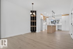 Open-concept living space with light wood-finish flooring - 