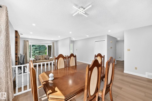 Spacious dining area featuring wood-finish flooring, recessed lighting, and a modern linear light fixture - 6208 11 Ave Nw Nw, Edmonton, AB - Indoor Photo Showing Dining Room