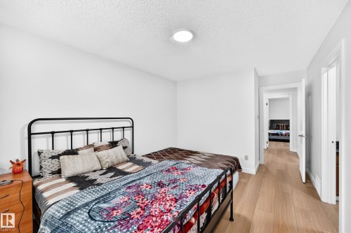 Bright bedroom featuring light wood-finish flooring and a neutral color palette - 6208 11 Ave Nw Nw, Edmonton, AB - Indoor Photo Showing Bedroom