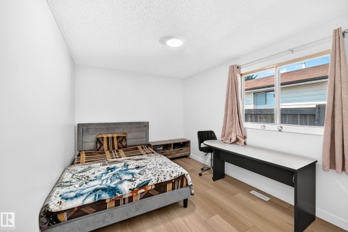Room featuring wood-finish flooring, white painted walls, and a multi-pane window - 6208 11 Ave Nw Nw, Edmonton, AB - Indoor Photo Showing Bedroom