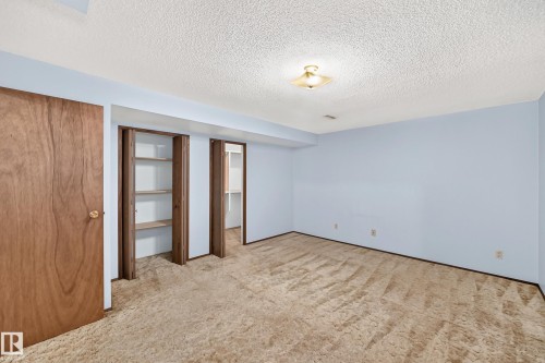 Spacious room featuring light blue walls, textured ceiling, and a flush mount ceiling light - 6208 11 Ave Nw Nw, Edmonton, AB - Indoor Photo Showing Other Room