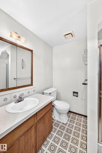 Bathroom featuring a wood-finish vanity with an integrated sink, white countertop, and tiled backsplash - 6208 11 Ave Nw Nw, Edmonton, AB - Indoor Photo Showing Bathroom